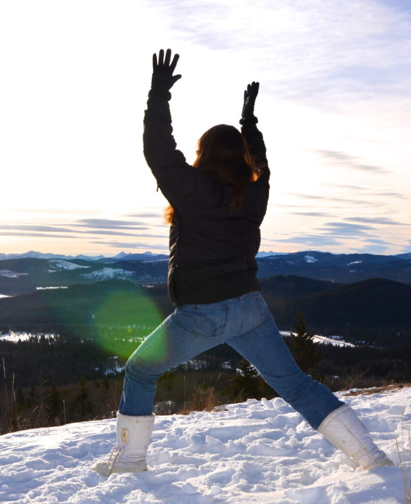 Rhonda doing yoga on a snow-covered mountain in winter clothes